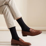 The ribbed socks worn with loafers below cropped stone trousers