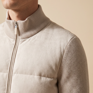 Close-up of the ribbed knit collar, quilted body and zip pull on the cream hybrid bomber