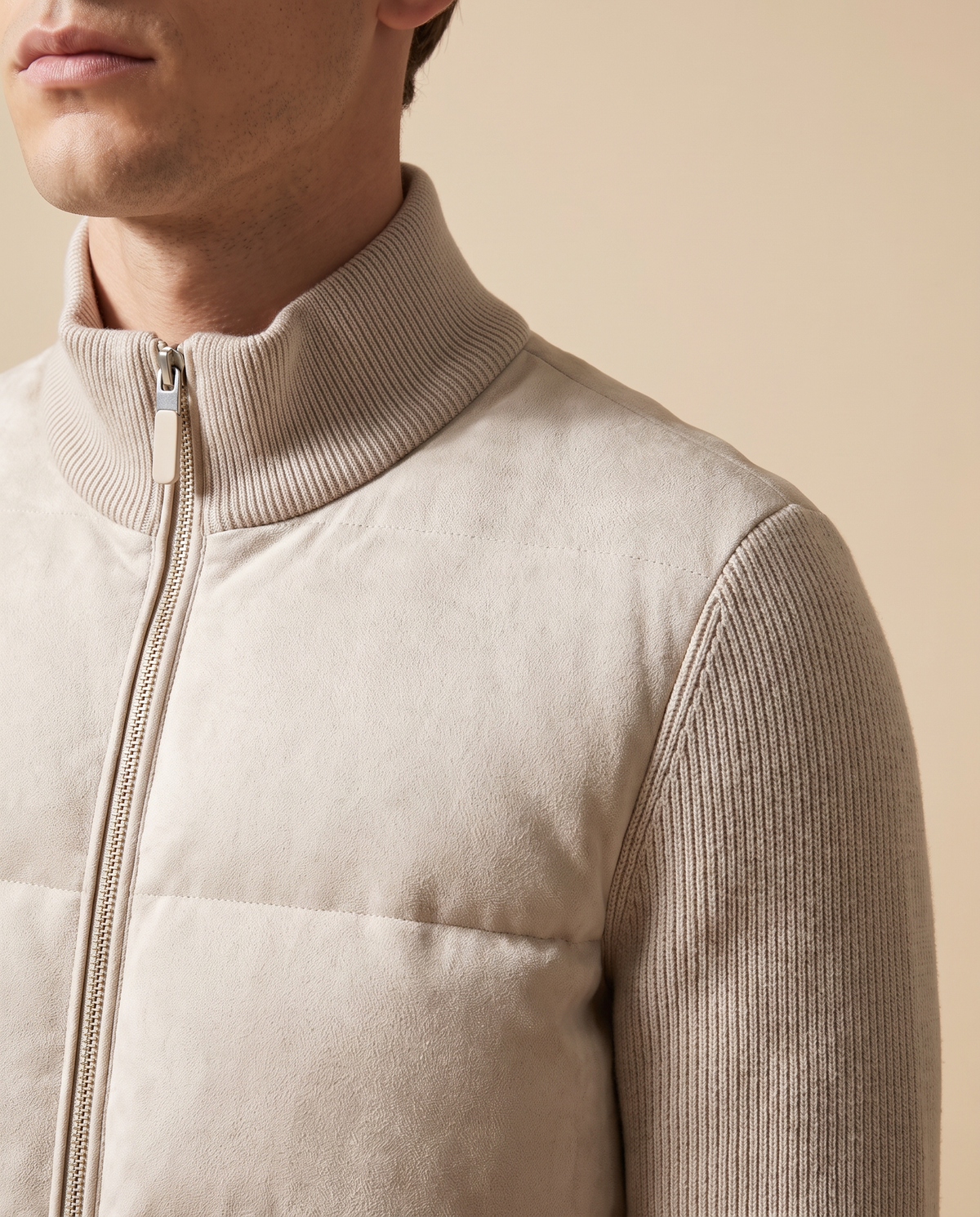 Close-up of the ribbed knit collar, quilted body and zip pull on the cream hybrid bomber