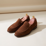 Cedar shoe trees shown inserted in a pair of suede loafers