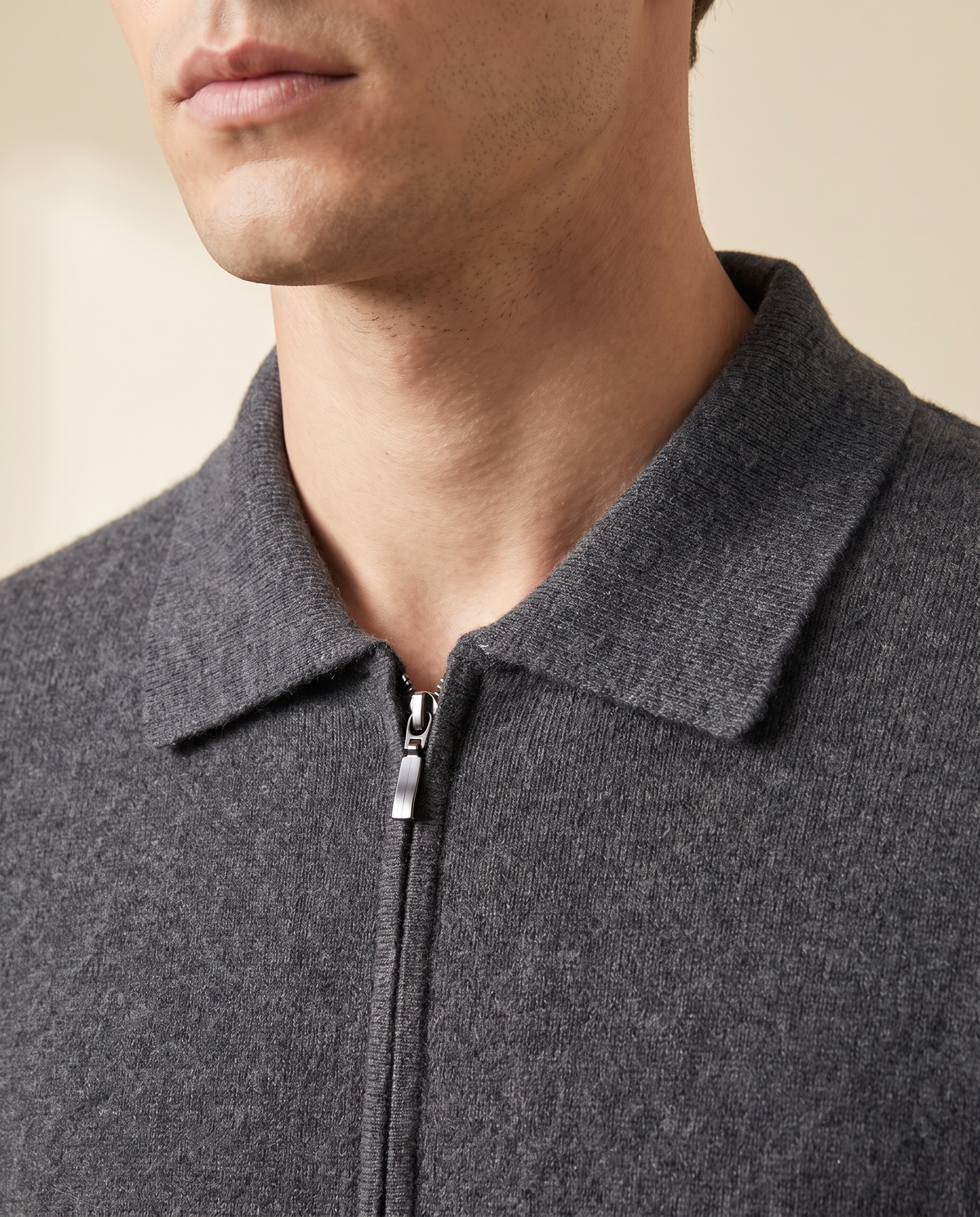 Close-up of the folded pointed collar and zip pull on the grey cashmere cardigan