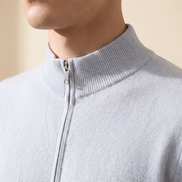 Close-up of the ribbed stand collar and zip pull on the light blue merino cardigan
