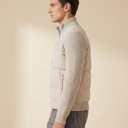 Model wearing the cream hybrid bomber, side profile showing knitted sleeve