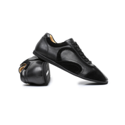 The Cadogan trainer in black, one shoe turned to show the lining