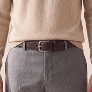 The Chester leather belt worn through the loops of plain grey trousers