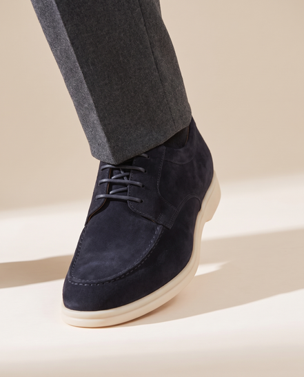 Close-up of The Regent worn, low three-quarter on the suede vamp, lacing and cream sole at the trouser break