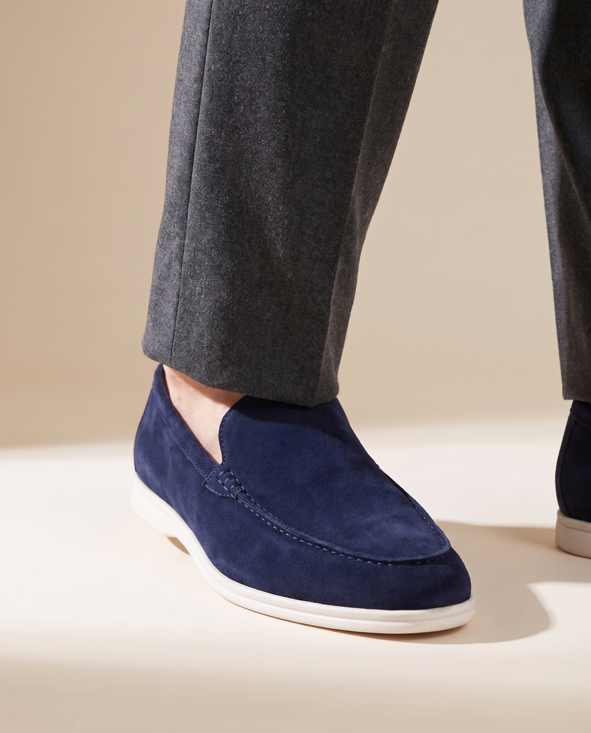 Close-up of The Bayswater worn, low three-quarter on the suede vamp and white sole at the trouser break
