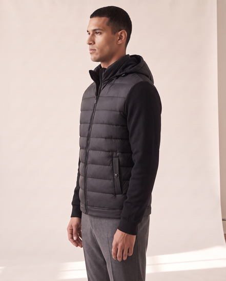 Model wearing The Norfolk Hybrid Down Jacket, side profile, hood up around the neck