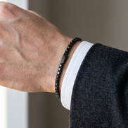 The Onslow Black Stone Tennis Bracelet under a shirt cuff